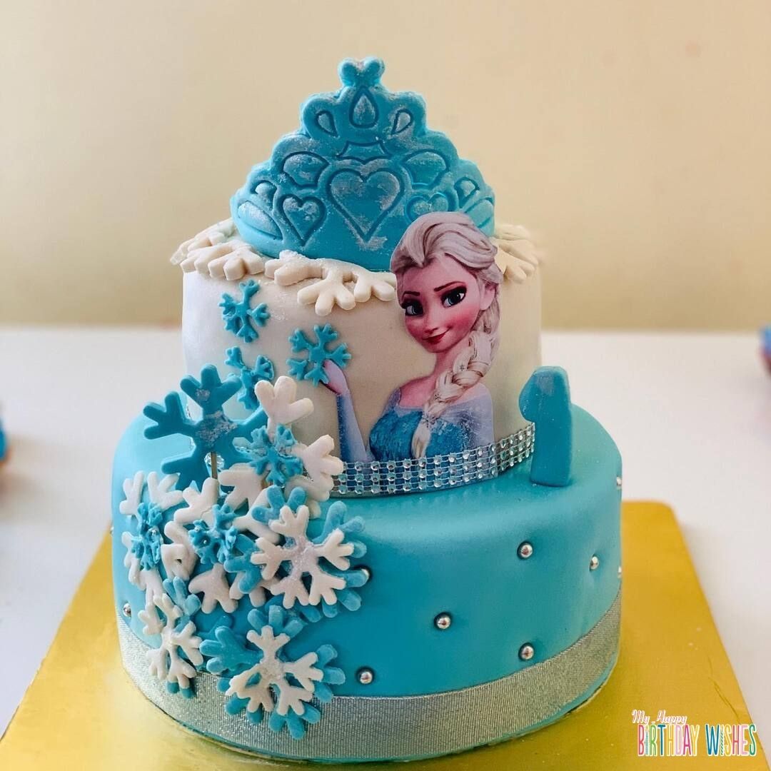 Elsa Two Tier Fondant Cake with different sizes of snow flake candy designs.