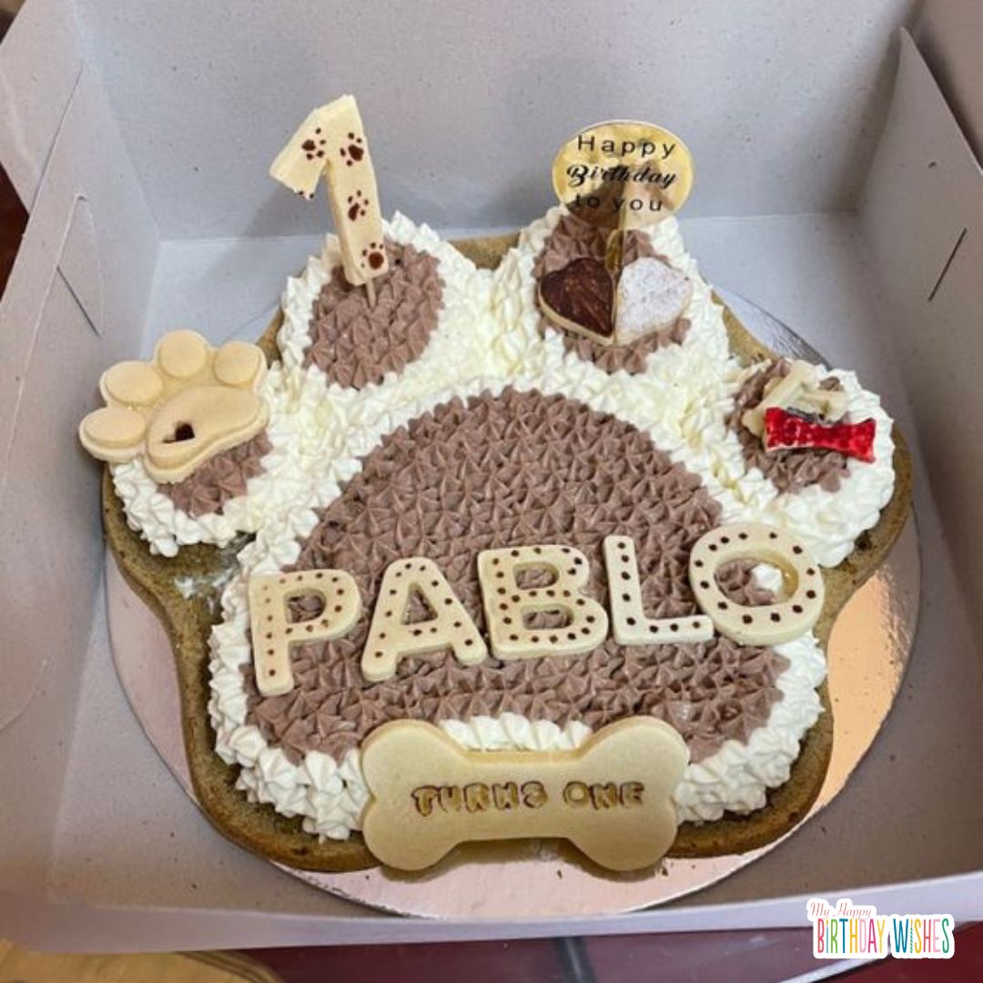 paw shaped cake with number 1 toppings and bone cookies